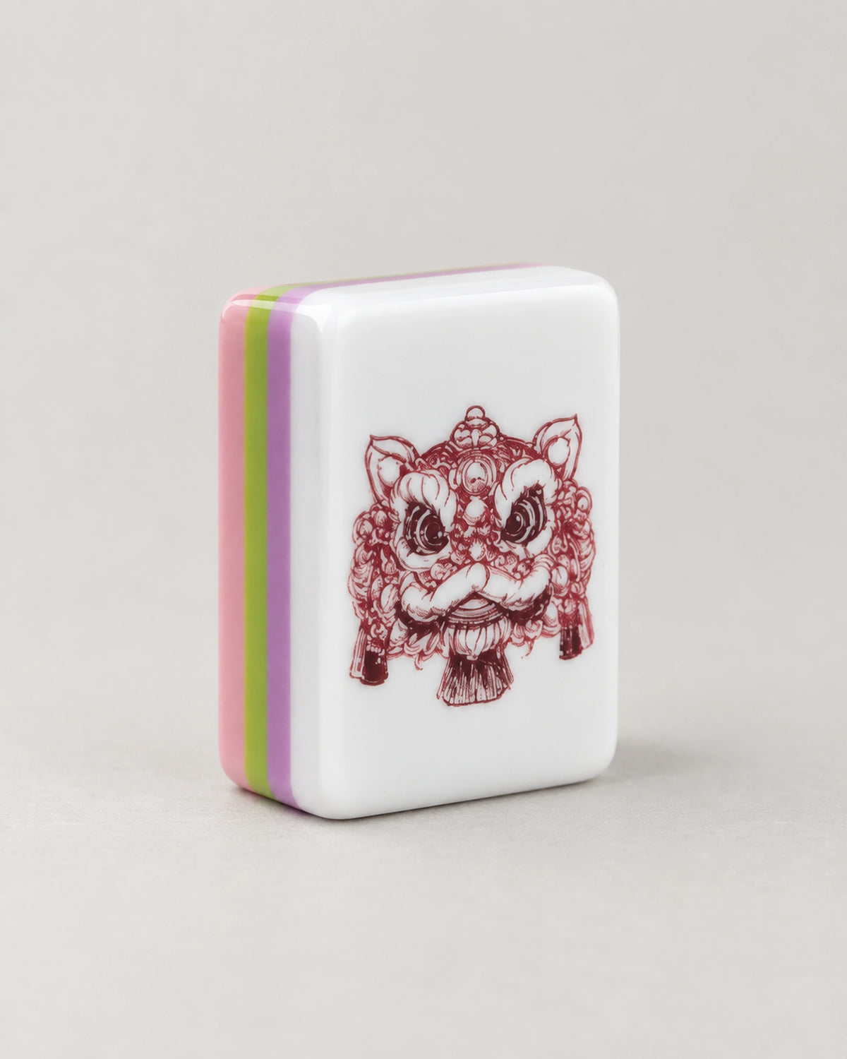 Close-up of a Begonia dragon tile with a red lion dance head, edges in pink, green and purple layers