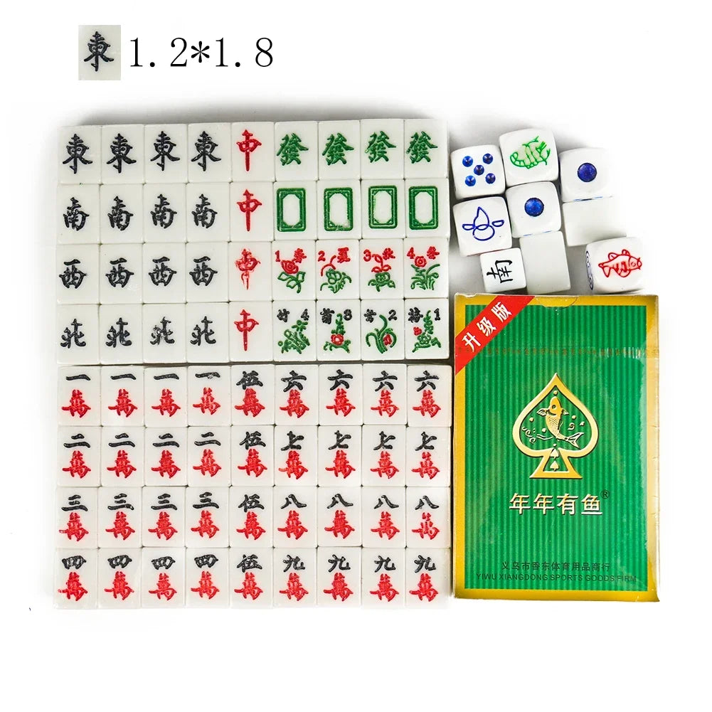 Carnelian mini tiles in rows of Chinese winds, dragons, flowers and characters, beside dice and a green card box