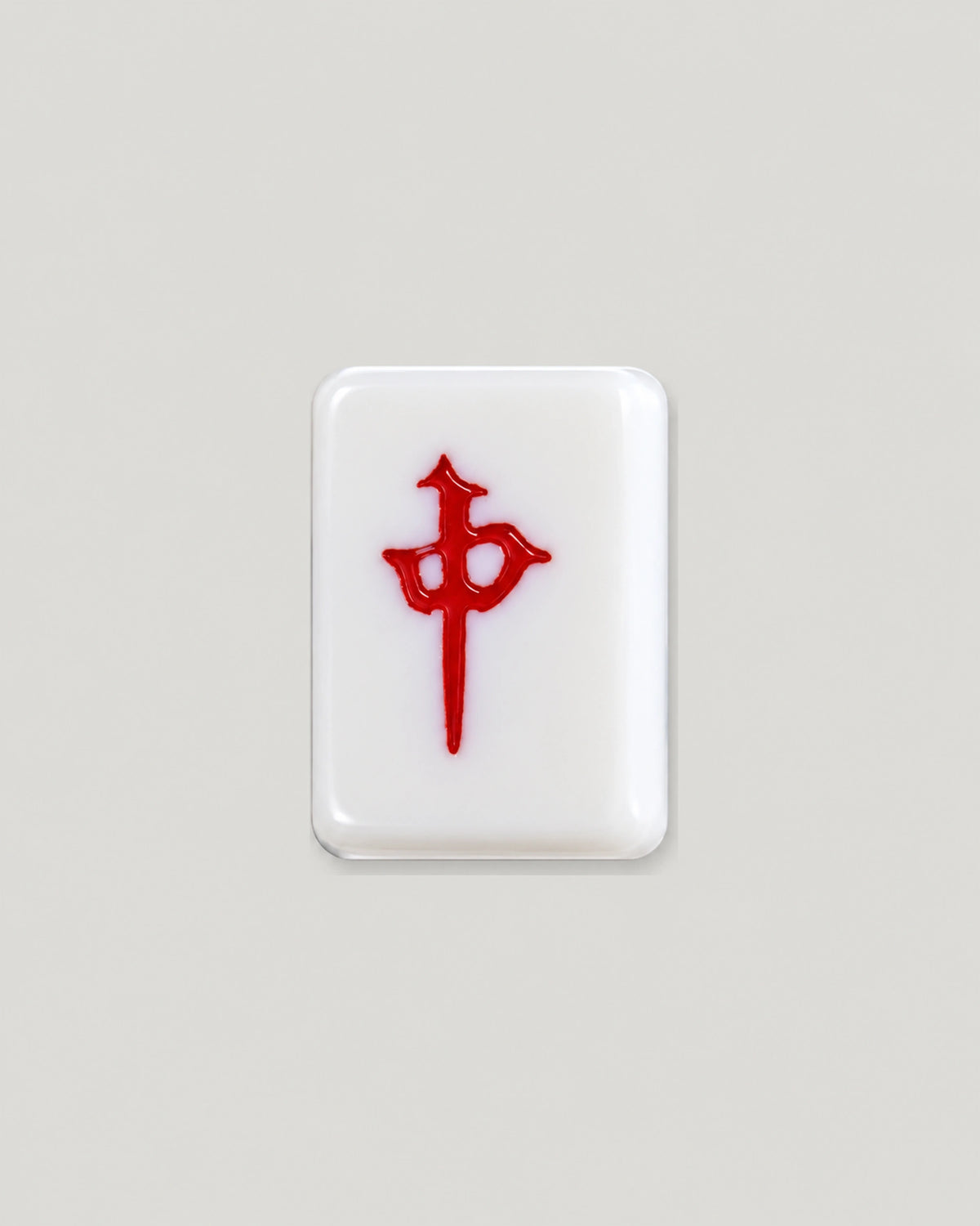 Close-up of one ivory Chestnut tile showing the red dragon character on a smooth face with rounded corners