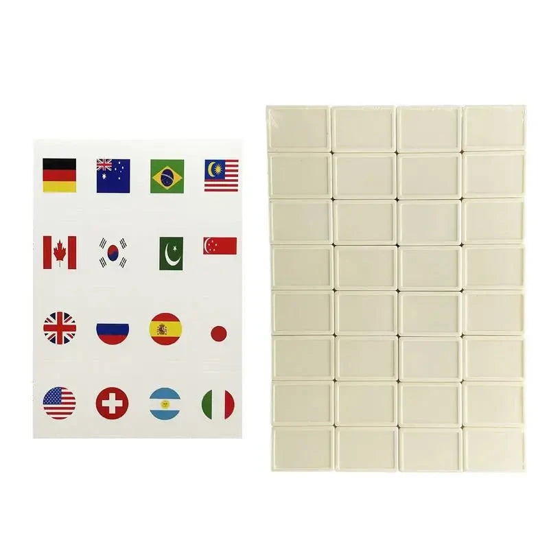 Blank mahjong tiles in cream, 32 laid out in rows beside a sheet of national flag stickers