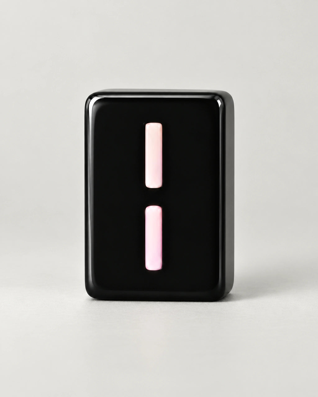 Close-up of a glossy black Indigo 2 Bamboo tile marked with two pale pink sticks