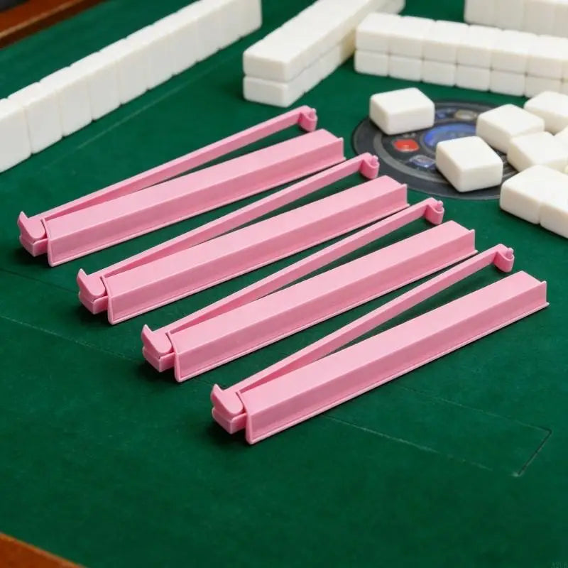 Four pink Larch racks lined up on a green game table, with white tiles and a stacked wall behind
