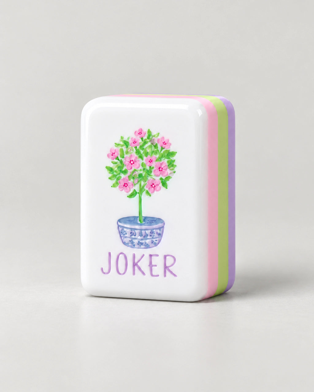 Lilac Joker tile with a pink shrub in a blue and white pot, and pink, green and lavender layers on its edge