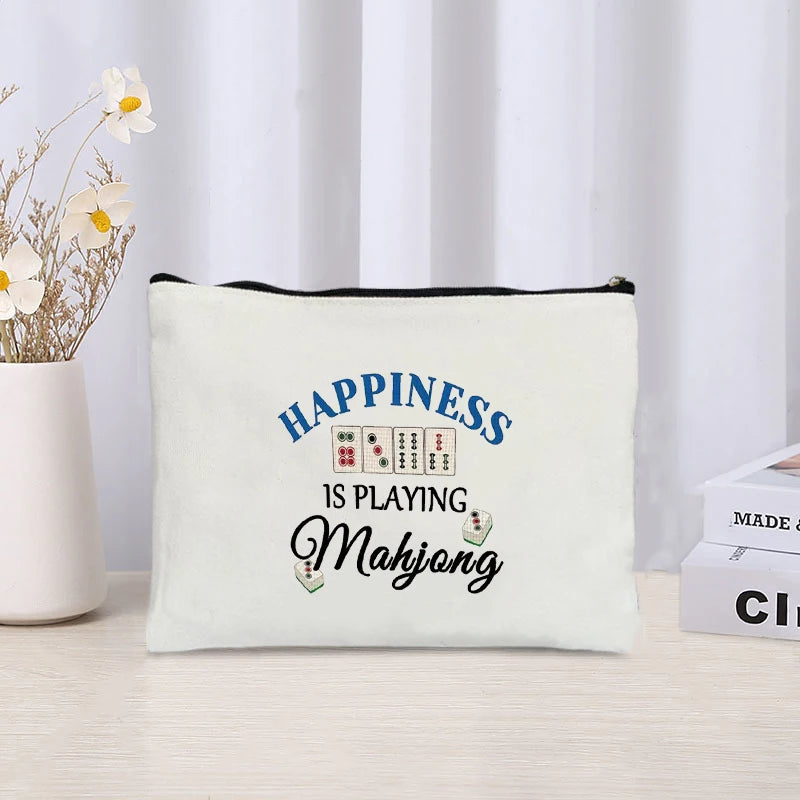 Linen pouch printed Happiness Is Playing Mahjong in blue and black lettering with small tile drawings
