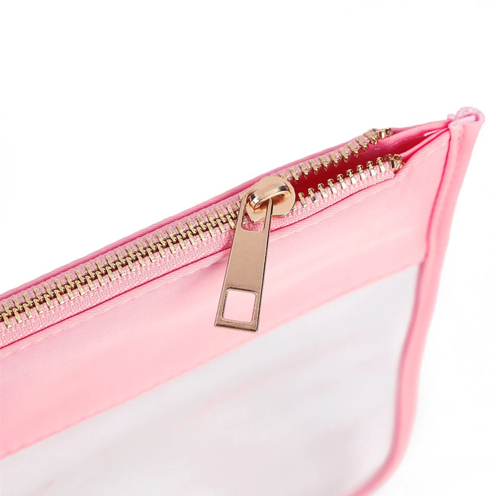 Close-up of the Papyrus zip: gold-tone metal teeth and pull above a peach pink band and clear panel