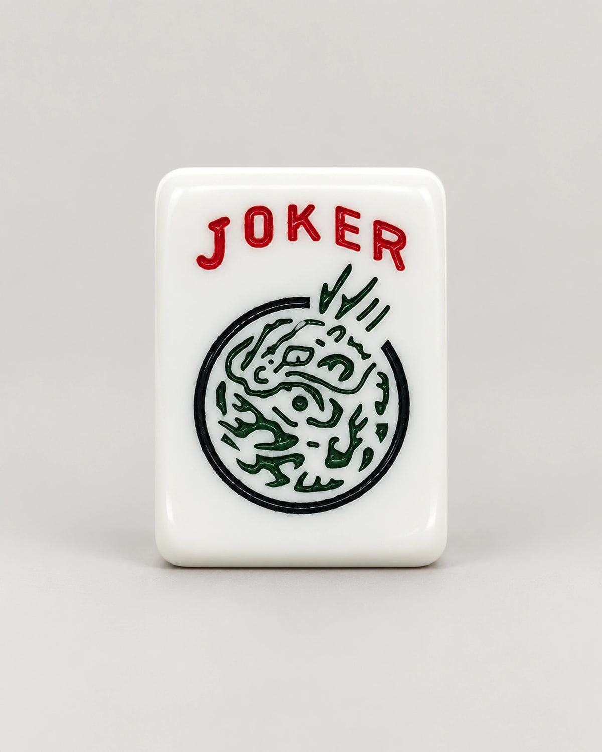 Close-up of a Poppy Joker tile: JOKER in red letters above a green dragon inside a black circle