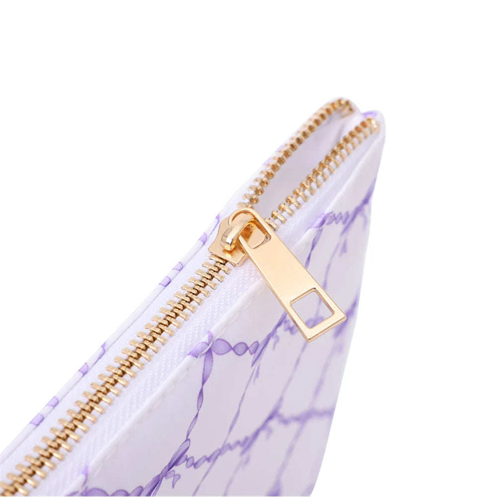 Close-up of the gold-tone zipper and pull on the Raffia purple bow print pouch
