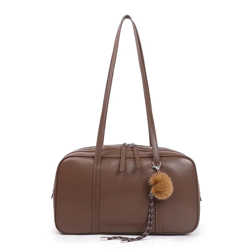 Chestnut brown Teak with long straps and a pom-pom charm on a braided cord clipped to the zip